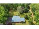 Aerial view of the property featuring a ranch-style home with a metal roof and a large wooded lot with mature trees at 725 & 761 School Road, Hampton, GA 30228