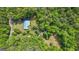 Wooded property featuring a home with a blue roof, outbuildings, and mature trees at 725 & 761 School Road, Hampton, GA 30228