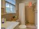 Retro bathroom featuring a shower with peach tile and a sink area with a basket of supplies at 1349 Springwood Nw Dr, Conyers, GA 30012