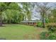 Traditional brick home nestled among mature trees and a lush green lawn, creating a serene setting at 1349 Springwood Nw Dr, Conyers, GA 30012