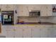 Kitchen has white cabinets, blue tile countertops and stainless steel microwave at 1349 Springwood Nw Dr, Conyers, GA 30012