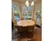 This charming dining area, bathed in natural light, offers serene views of the sparkling pool and verdant backyard at 374 Persimmon Dr, Sharpsburg, GA 30277