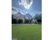 Beautiful brick home with manicured landscaping, lush green lawn, and mature trees at 374 Persimmon Dr, Sharpsburg, GA 30277