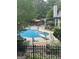 Inviting backyard pool area surrounded by mature trees, outdoor kitchen, and manicured landscaping at 374 Persimmon Dr, Sharpsburg, GA 30277
