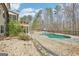 Backyard featuring a pool and stone pavers alongside a path up to an elevated deck; surrounded by mature trees at 108 Turnberry Trce, Sharpsburg, GA 30277