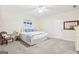 Bright bedroom with neutral walls, carpet, a bed with blue accents, and soft natural light at 108 Turnberry Trce, Sharpsburg, GA 30277