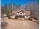 Two-story home with tan siding, brown trim, and a large front yard with landscaping and a curved driveway at 108 Turnberry Trce, Sharpsburg, GA 30277