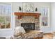 Stone fireplace with wooden mantle and decor flanked by two windows at 108 Turnberry Trce, Sharpsburg, GA 30277