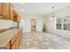 Bright kitchenette with tiled floor, wood cabinets, countertop, and view to the yard at 108 Turnberry Trce, Sharpsburg, GA 30277