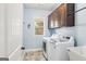 Laundry room featuring a washer and dryer, overhead cabinet and a utility sink at 108 Turnberry Trce, Sharpsburg, GA 30277