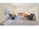 The living room has neutral carpet and walls, with a brown couch and two blue chairs plus lots of natural light at 108 Turnberry Trce, Sharpsburg, GA 30277