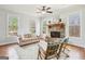 Living room with stone fireplace, large windows, and comfortable seating at 108 Turnberry Trce, Sharpsburg, GA 30277