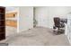 Bright carpeted office space with desk, chair, cabinets, and hallway access to the kitchen at 108 Turnberry Trce, Sharpsburg, GA 30277