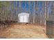 Backyard storage shed with double doors and a small deck located in a partially wooded area at 108 Turnberry Trce, Sharpsburg, GA 30277