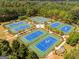 Aerial view of numerous blue tennis courts surrounded by manicured landscaping and mature trees at 2019 Emerald Dr, Jonesboro, GA 30236
