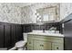 Charming bathroom featuring decorative wallpaper, a green vanity and a contrasting dark wainscotting at 2019 Emerald Dr, Jonesboro, GA 30236