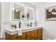 Bathroom vanity with double sinks, wood cabinets, marble countertop, and decorative mirror with lighting at 2019 Emerald Dr, Jonesboro, GA 30236