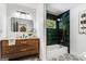 Stylish bathroom showcasing a wood vanity, decorative tile floor and bathtub with green tile surround and gold fixtures at 2019 Emerald Dr, Jonesboro, GA 30236