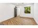 Bright bedroom features wood floors, white walls, a black door and a window with view of surrounding trees at 2019 Emerald Dr, Jonesboro, GA 30236