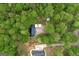 Aerial photograph showing a home with lush forest, driveway, and storage buildings at 7616 Nicholson Rd, Cumming, GA 30028