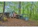 Outside shot of animal pen and storage buildings bordered by a dense, wooded area at 7616 Nicholson Rd, Cumming, GA 30028
