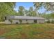 View of the rear exterior featuring a metal roof, sliding door, and small patio at 7616 Nicholson Rd, Cumming, GA 30028