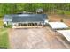 Aerial view of home with a dark metal roof, large porch, and ample parking, showcasing a serene residential setting at 7616 Nicholson Rd, Cumming, GA 30028