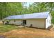 Back exterior with a sliding glass door leading to a stone patio and grassy yard at 7616 Nicholson Rd, Cumming, GA 30028