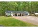Charming home with a covered front porch, lush landscaping, and a metal roof at 7616 Nicholson Rd, Cumming, GA 30028