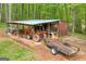 Outbuilding with orange tractor and trailer for equipment and storage at 7616 Nicholson Rd, Cumming, GA 30028