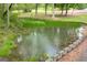View of a quiet pond surrounded by lush foliage, providing a serene and picturesque setting at 7616 Nicholson Rd, Cumming, GA 30028