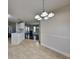 Open dining area with modern lighting and a view of the kitchen and living room at 321 Shadowbrooke Dr, Loganville, GA 30052