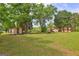 Large backyard with mature trees and utility buildings at 171 Wynn Dr, Hampton, GA 30228