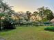 Landscaped backyard with blooming trees, manicured lawn, and partial fence at 171 Wynn Dr, Hampton, GA 30228