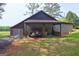 The side of a shed with a covered area is filled with equipment and building material at 171 Wynn Dr, Hampton, GA 30228