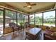 Relaxing sunroom with wicker furniture and large windows offering views of the outdoor pool and backyard at 171 Wynn Dr, Hampton, GA 30228