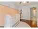 Bedroom featuring wood floors, a white crib, and elegant peach colored wall trim at 139 Crown Forest Dr, Mcdonough, GA 30252