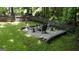 A stone fire pit with chairs is surrounded by a wooden fence and lush green grass at 139 Crown Forest Dr, Mcdonough, GA 30252