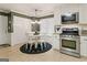 Eat-in kitchen with stainless steel appliances, white cabinetry, and a cozy dining area at 139 Crown Forest Dr, Mcdonough, GA 30252
