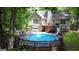 Backyard pool surrounded by a wooden deck with stairs and a slide in a wooded setting at 139 Crown Forest Dr, Mcdonough, GA 30252