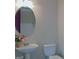 Bright bathroom featuring a pedestal sink, round mirror, and white toilet at 30 Cynthia Ct, Fayetteville, GA 30215