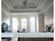 Sunlit main bedroom with large windows, ceiling fan, and tray ceiling at 30 Cynthia Ct, Fayetteville, GA 30215