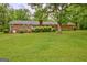 Back exterior of brick ranch home featuring a lush green lawn and mature shade trees at 110 Silver Leaf Dr, Fayetteville, GA 30214