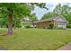 Charming brick home with a green lawn, lush landscaping, and an attached one-car garage at 110 Silver Leaf Dr, Fayetteville, GA 30214