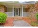 Covered front porch of a brick home with white columns and brick steps, framed by greenery at 110 Silver Leaf Dr, Fayetteville, GA 30214