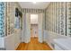 Mud room with floral wallpaper, white bi-fold closet doors, and wood floors at 110 Silver Leaf Dr, Fayetteville, GA 30214