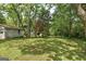 Spacious backyard with mature trees, detached garage, and fenced perimeter at 19 Mcdonough St, Hampton, GA 30228