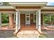 Inviting covered front porch with white columns and a seating area for relaxing at 19 Mcdonough St, Hampton, GA 30228