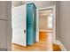 Hallway featuring a rustic pantry door and hardwood floors leading to other rooms at 19 Mcdonough St, Hampton, GA 30228