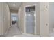 Hallway access to a bright bathroom with a glass enclosed shower, neutral walls, and ample cabinet space at 8040 Classic Dr, Jonesboro, GA 30236